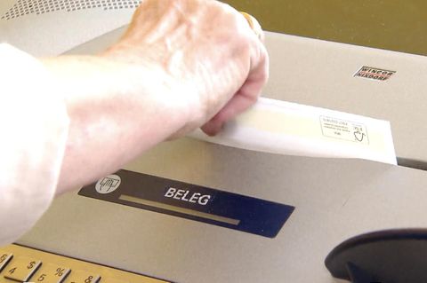 Ein Kontoauszug kommt aus der Maschine.