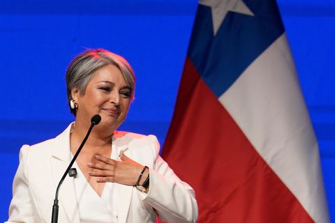 Jeannette Jara, Präsidentschaftskandidatin in Chile, fasst sich auf einer Bühne lächelnd mit links ans Herz