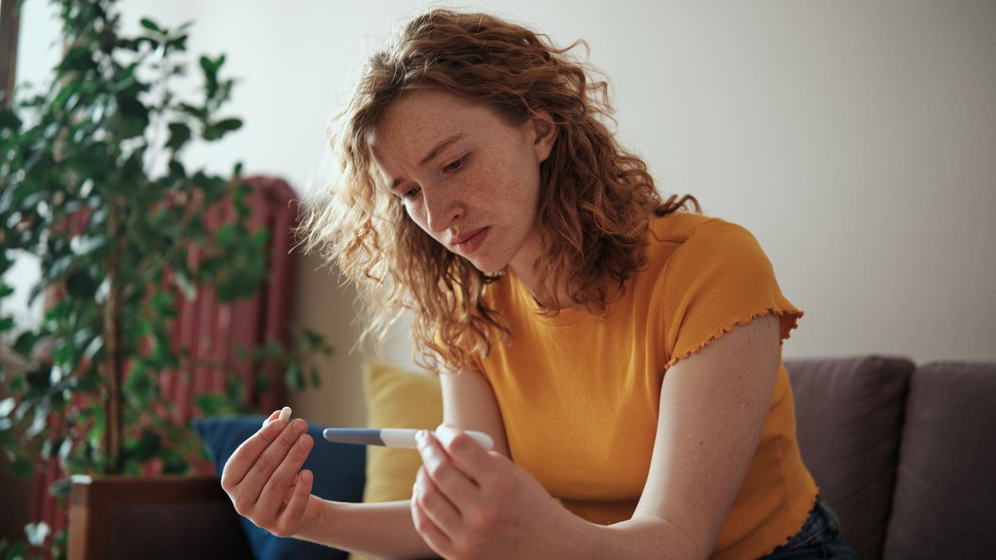 Frau schaut auf ihren Schwangerschaftstest