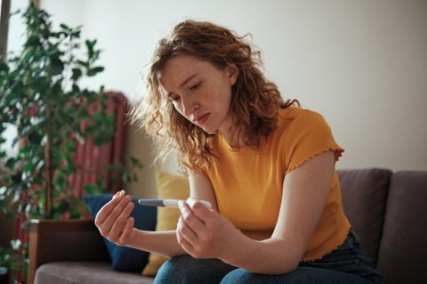 Frau schaut auf ihren Schwangerschaftstest