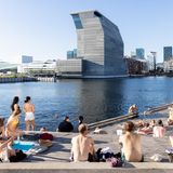 Menschen auf einer Terrasse am Wasser