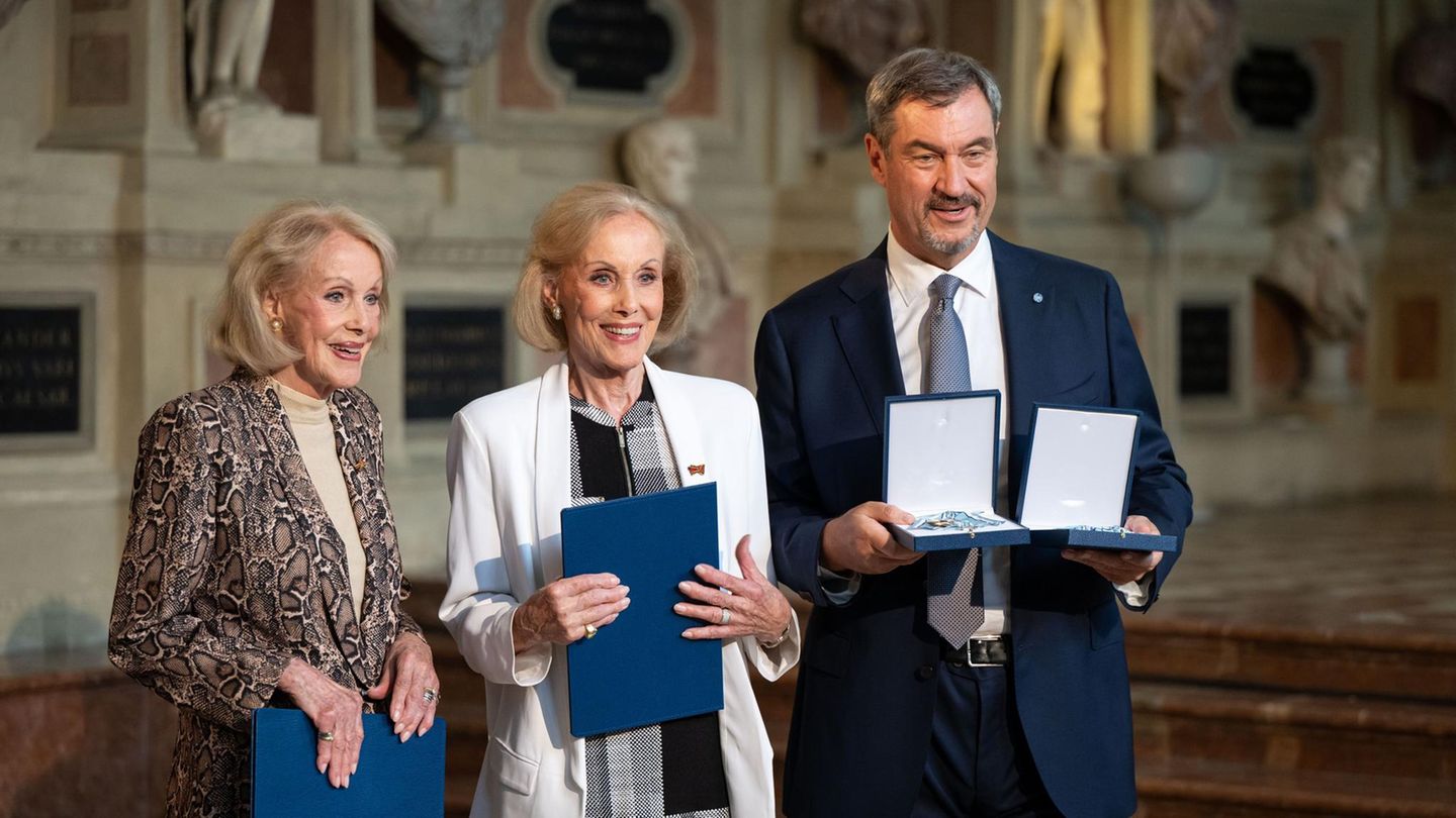 Im Juli 2025 haben sie einen letzten großen Auftritt. Markus Söder, Ministerpräsident von Bayern, verleiht den Zwillingen den Bayerischen Verdienstorden