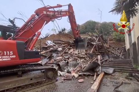 Ein Bagger der Feuerwehr schaufelt Trümmer aus einem Erdrutsch in Brazzano di Cormons in Norditalien