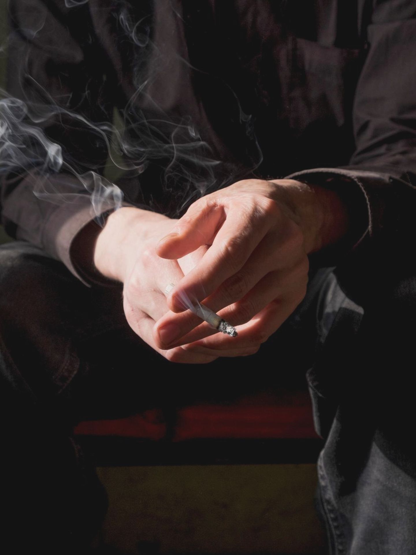 Mann beim Rauchen mit Zigarette in der Hand