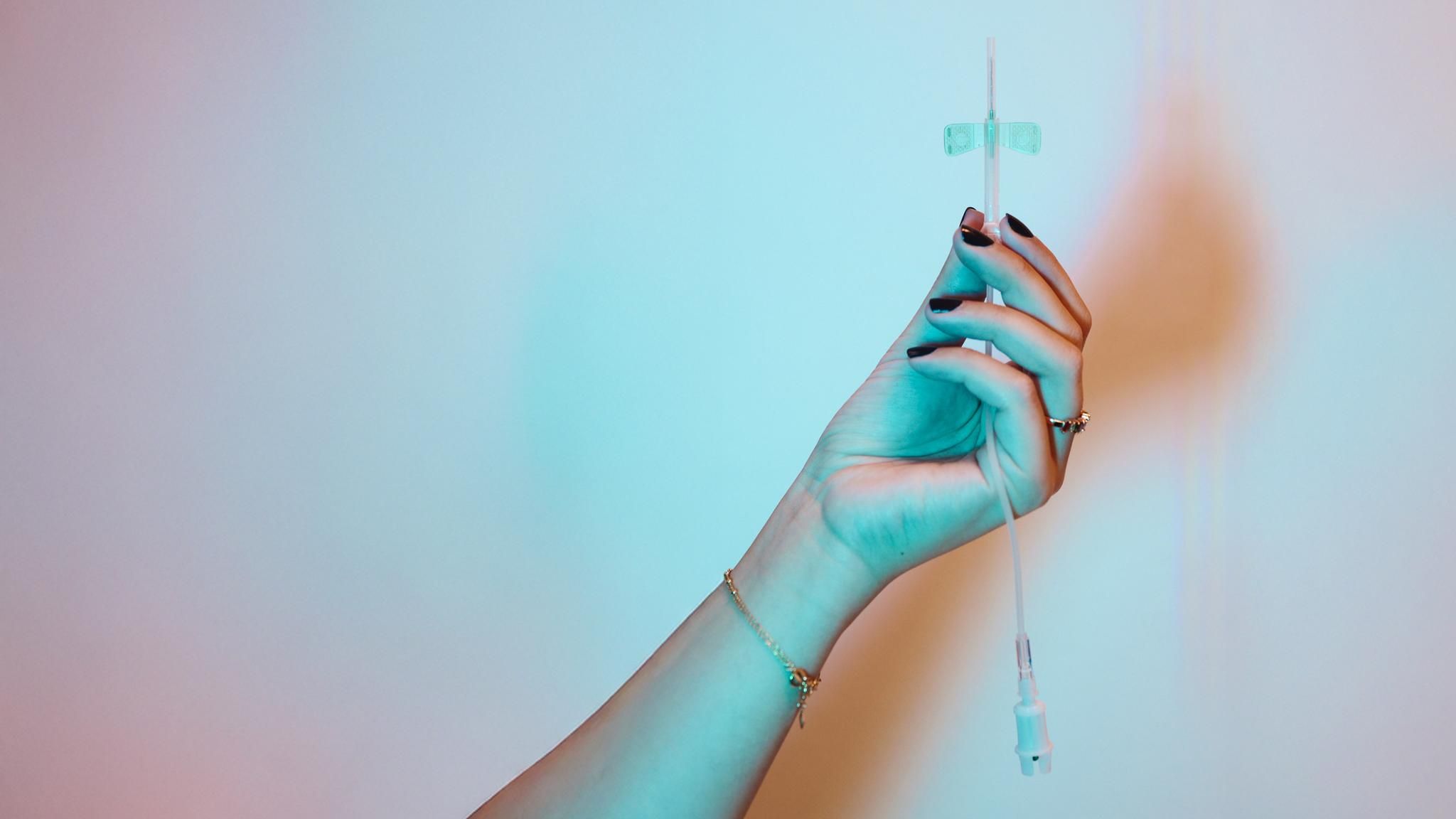 Person mit einer Phobie vor Spritzen hält eine Nadel in der Hand