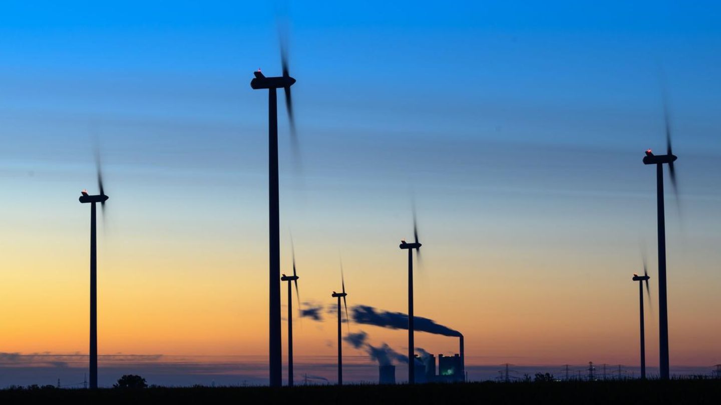 Windräder drehen sich vor der Kulisse des Braunkohlekraftwerkes Schkopau in Sachsen-Anhalt