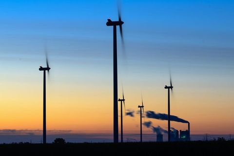 Windräder drehen sich vor der Kulisse des Braunkohlekraftwerkes Schkopau in Sachsen-Anhalt