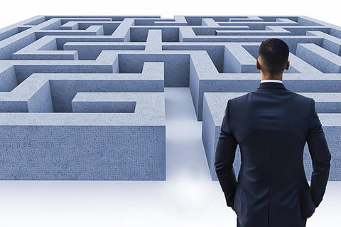 Ein Mann steht vor einem Labyrinth (Symbolbild Quiz)