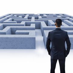 Ein Mann steht vor einem Labyrinth (Symbolbild Quiz)