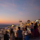 Menschenmenge, die bei Sonnenuntergang über die Dächer guckt