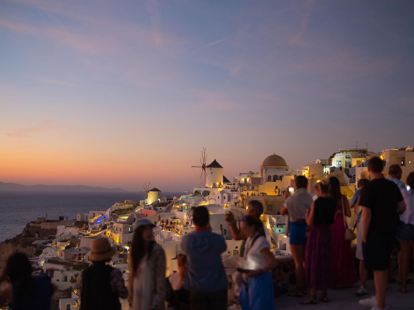 Menschenmenge, die bei Sonnenuntergang über die Dächer guckt