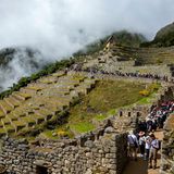 Schlange an Menschen auf den Wegen einer Ruine am Berg zu Machu Picchu