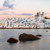 Weiße Häuser am Wasser in Paros, der Himmel in rosa-Tönen