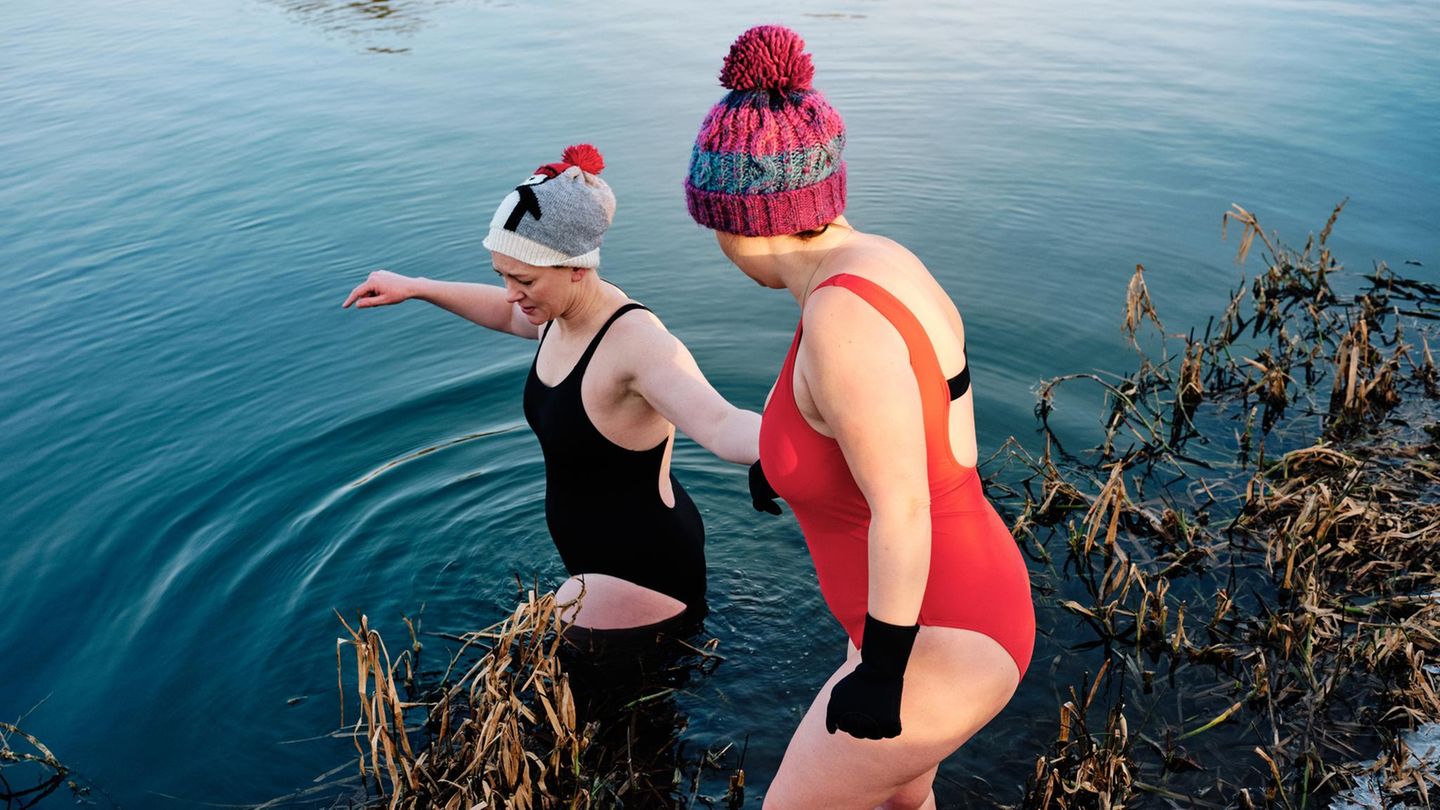 zwei Frauen gehen im Winter in einen See