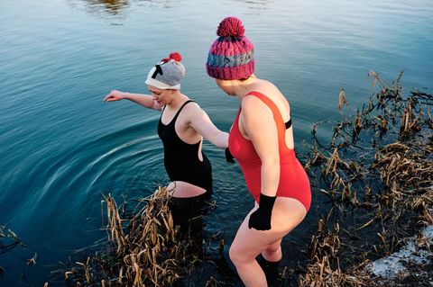 zwei Frauen gehen im Winter in einen See