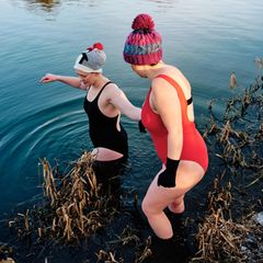 zwei Frauen gehen im Winter in einen See