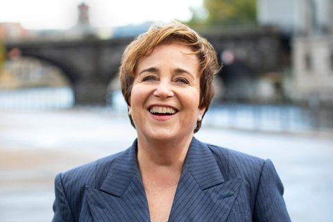 Katharina Franck im grauen Anzug am Ufer der Spree in Berlin