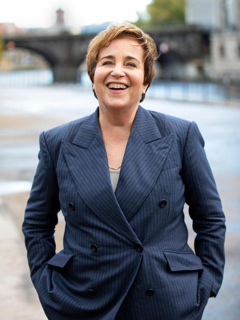 Katharina Franck im grauen Anzug am Ufer der Spree in Berlin