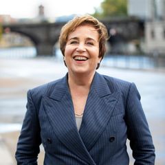 Katharina Franck im grauen Anzug am Ufer der Spree in Berlin