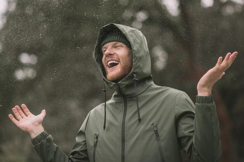 59 % Rabatt auf Amazon: Junger Mann steht mit Softshell-Jacke im Regen