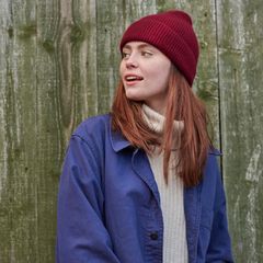 Deals und Angebote: Junge Frau mit weinrotem Beanie und blauer Jacke