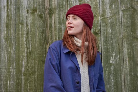 Deals und Angebote: Junge Frau mit weinrotem Beanie und blauer Jacke