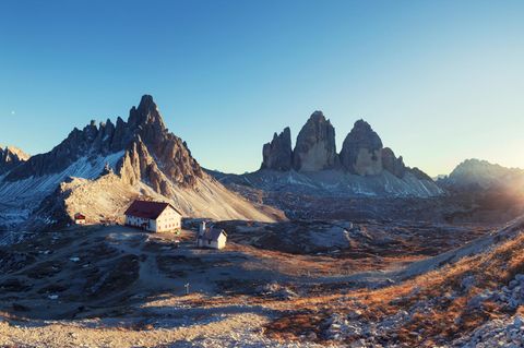 Berg-Panorama: Blick auf Schutzhütte Refugio Antonio Locatelli unweit der aufragenden Drei Zinnen bei Sonnenuntergang
