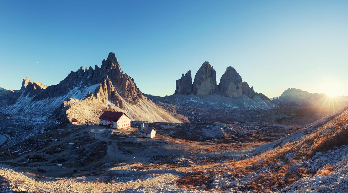 Berg-Panorama: Blick auf Schutzhütte Refugio Antonio Locatelli unweit der aufragenden Drei Zinnen bei Sonnenuntergang
