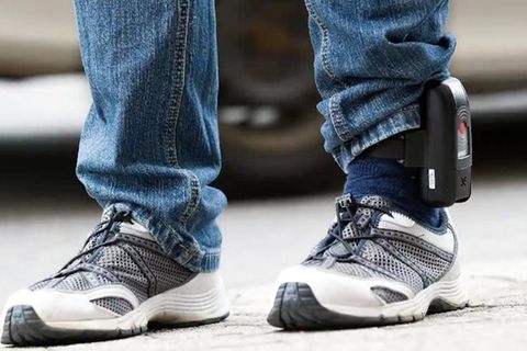 Ein Mann mit einer Fußfessel. Die Hose ist seitlich über dem Gerät hochgezogen.