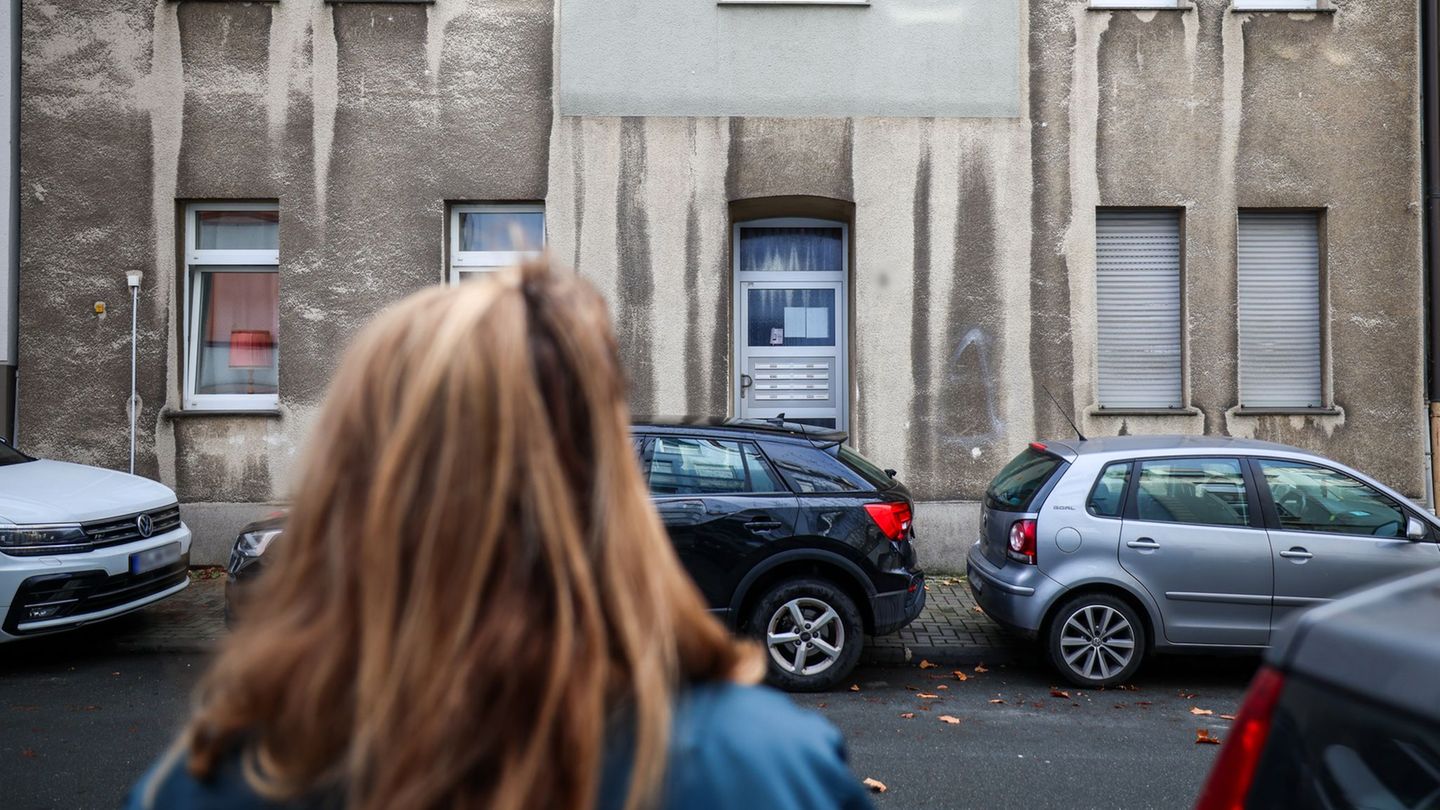 Eine Frau steht vor dem Mehrfamilienhaus, in dem ein zwölfjähriges Mädchen bei einem Polizeieinsatz durch Schüsse lebensgefährli