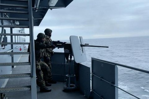 Soldaten feuern Munition vom Kriegsschiff mit dem Namen "Berlin"