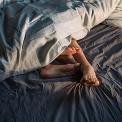 Sex: Personen unter einer Decke, Füße sind zu sehen