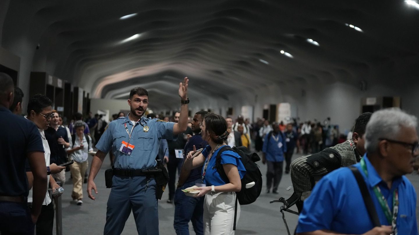 Menschen verlassen das Gelände der Weltklimakonferenz COP 30 wegen eines Feuers. Foto: Fernando Llano/AP/dpa