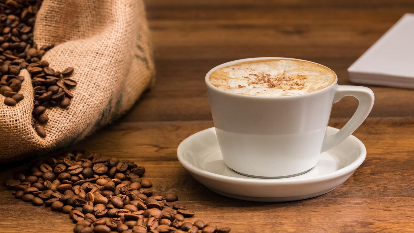 Deal News: Eine Kaffeetasse steht neben Kaffeebohnen auf einem Tisch