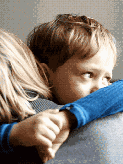 Ein Kind liegt in den Armen seiner Mutter