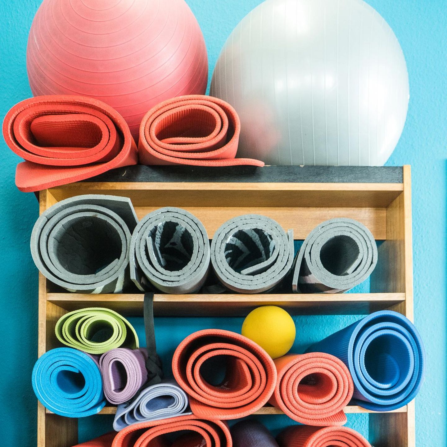 Ein Regal mit Fitnessmatten und Bällen