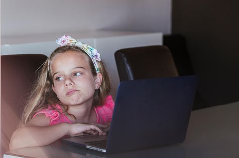 Kinder: Ein Mädchen sitzt unkonzentriert am Rechner