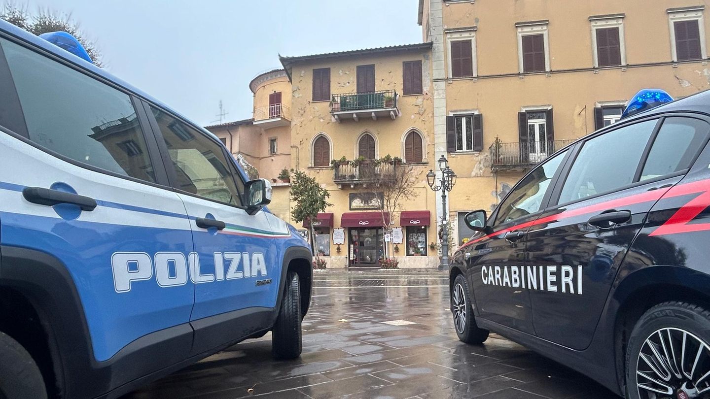 Zwei Autos der italienischen Polizei und der Carabinieri stehen vor einem Gebäude