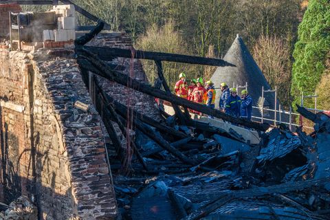 Einsatzkräfte inspizieren das ausgebrannte Dachgeschoss von Schloss Hardenberg. (Luftaufnahme mit einer Drohne) Foto: Christoph