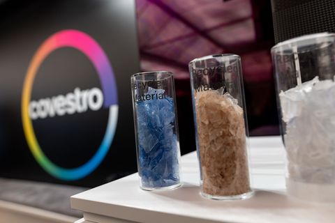 Eine deutsche Firma wird arabisch: Das Logo des Spezialchemie-Konzerns in einem Firmen-Showroom, davor Gläser mit Covestro-Mater