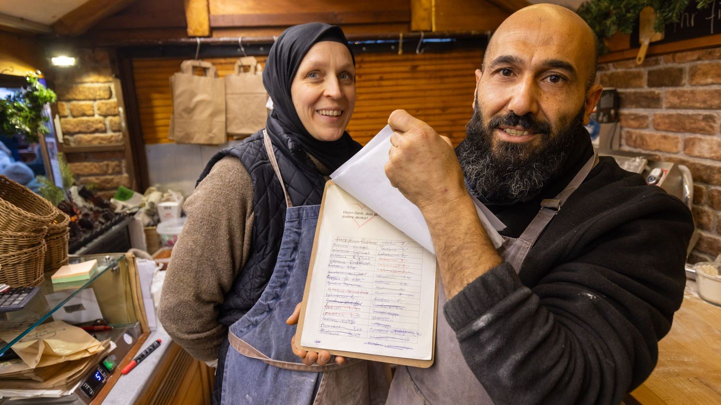 Auf einer Liste notieren Bayram Dalkilic und seine Frau Isabell Geldspenden, mit denen Kunden kostenloses Essen für bedürftige M