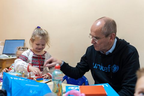 Der Geschäftsführer von Unicef Deutschland, Christian Schneider, mit einem ukrainischen Vorschulkind in einem Schutzraum unter d