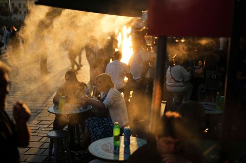Mehrere Menschen sitzen vor einem Imbiss