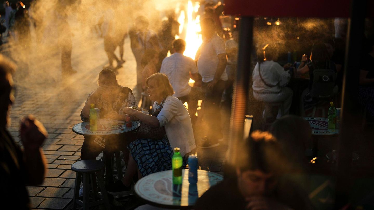 Mehrere Menschen sitzen vor einem Imbiss
