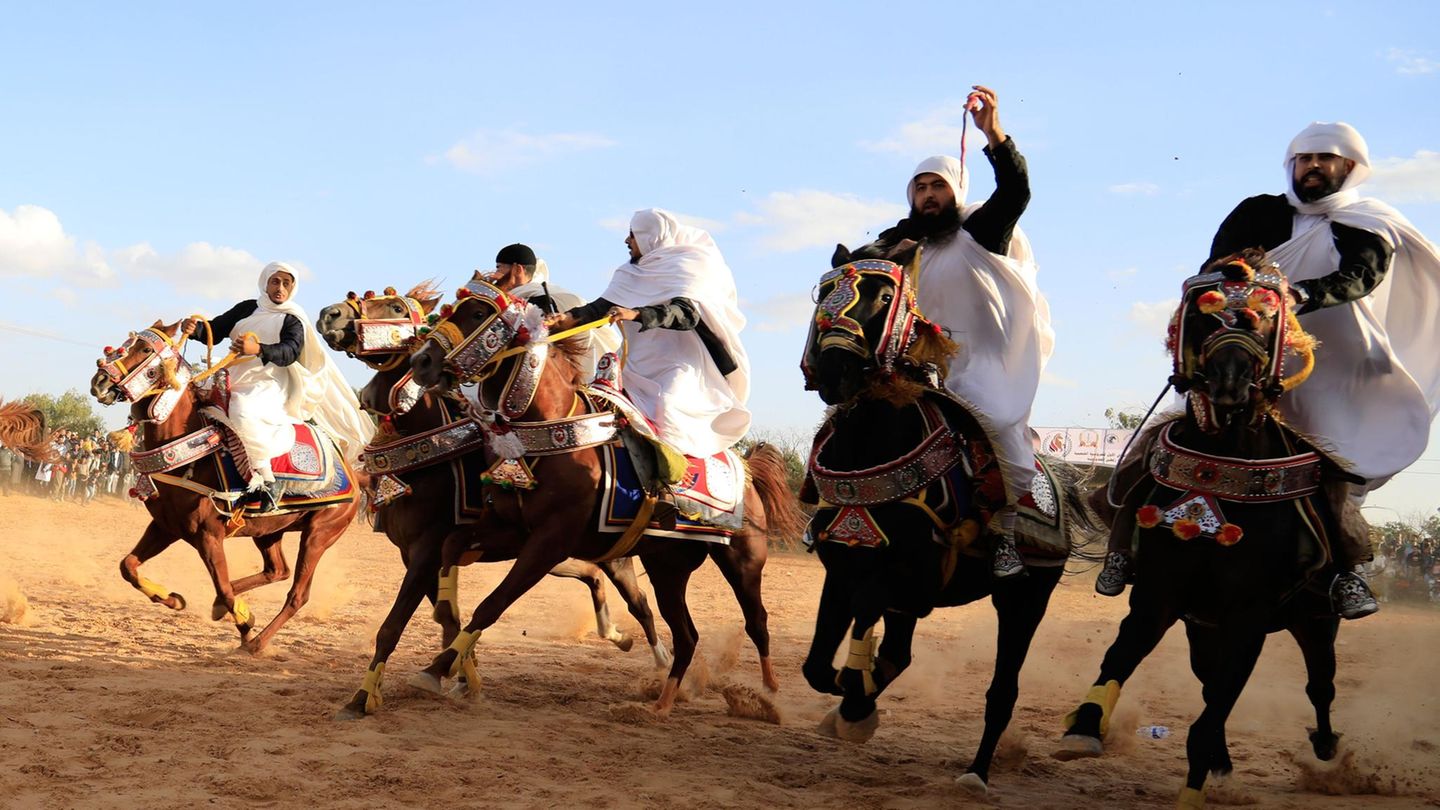Zelten, Libyen. Bei einem traditionellen Reiterfestival westlich der Hauptstadt Tripolis treiben Männer ihre Pferde durch den Sand. Die Tradition trägt auf Arabisch den Namen El Maiz (in Englisch auch Fantasia) und findet üblicherweise im Rahmen verschiedener Feste im ganzen Land statt