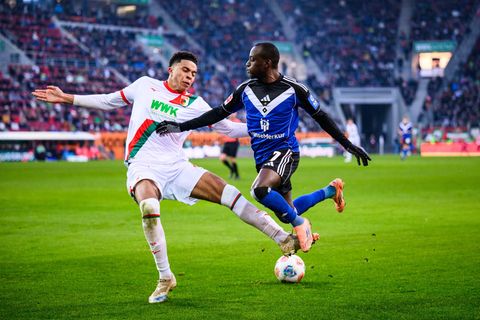 Augsburgs Noahkai Banks im Zweikampf mit Jean-Luc Dompé vom HSV. Foto: Tom Weller/dpa