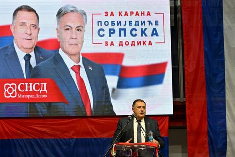 Dodik im Wahlkampf vor einem Plakat mit Karan