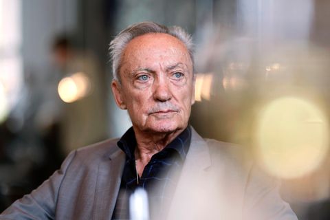 Udo Kier schaut links am Betrachter vorbei in die Ferne