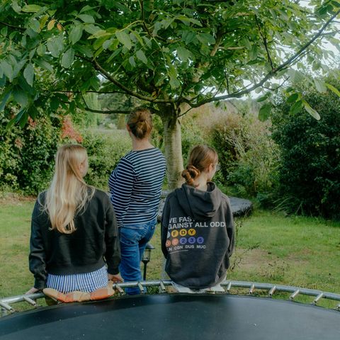 Mutter und Töchter mit Autismus-Spektrum-Störung: von hinten im Garten fotografiert