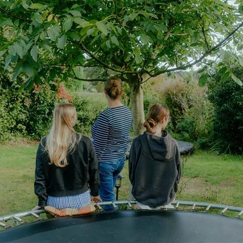 Mutter und Töchter mit Autismus-Spektrum-Störung: von hinten im Garten fotografiert
